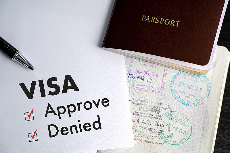 签证和护照到批准盖章的文件上俯视图在移民签证批准
