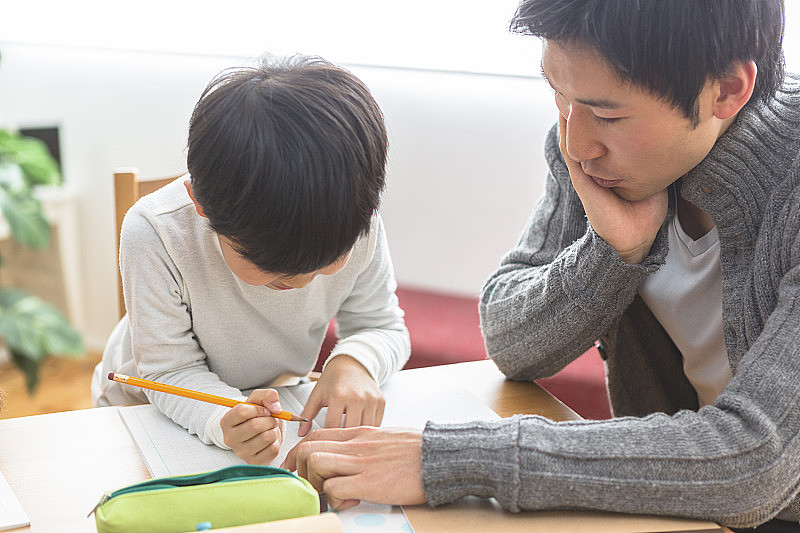 学习的孩子和观看学习的父母