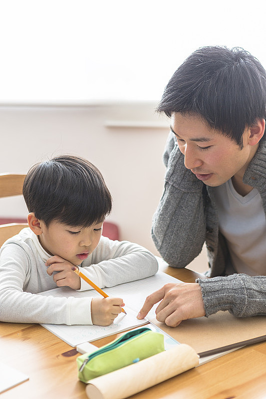 学习的孩子和观看学习的父母