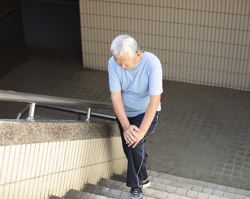 老年男性在楼梯上膝盖疼痛