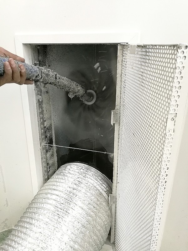 软焦点技术人员使用吸尘器和刷子清洁风管。