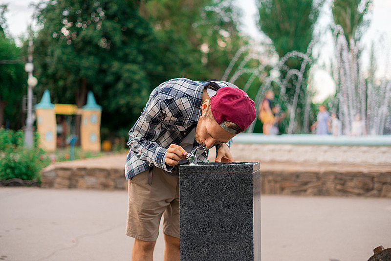 年轻人口渴，喝公共城市喷泉的水