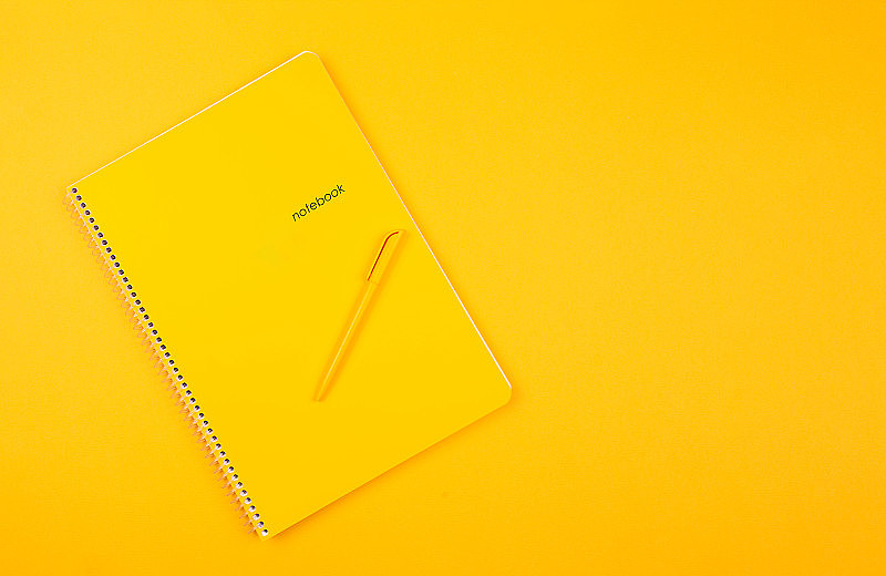 2020年计划。白色的笔记本上，黄色的背景，黄色的笔，一年的目标。