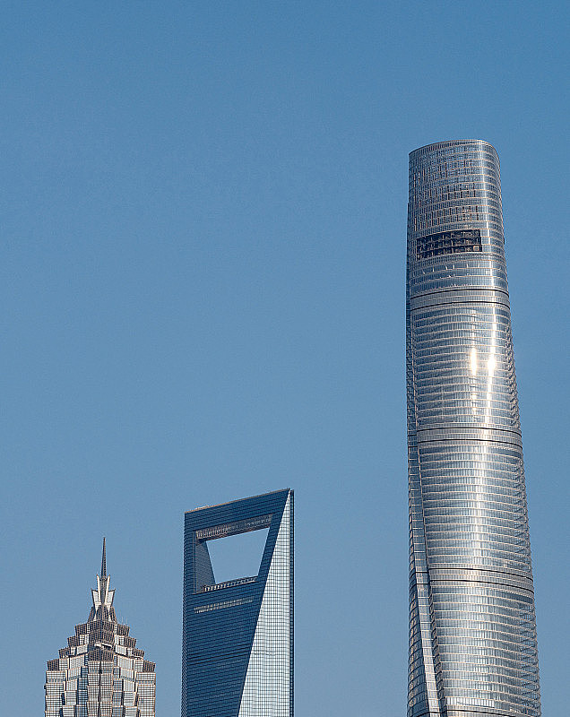 近距离拍摄上海陆家嘴、上海中心大厦、金茂大厦和上海环球金融中心等现代摩天大楼，以蓝天为背景。