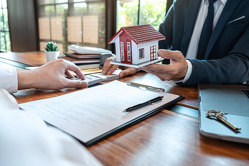房地产经纪人出示住房贷款和发送钥匙客户签署合同后，以批准的财产申请表格购买房子，保险home概念