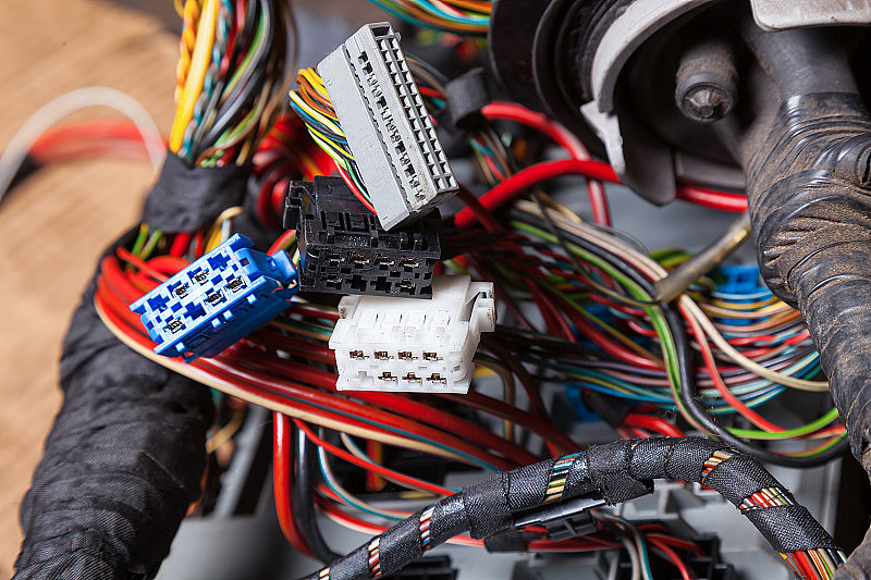 多色电线与连接器的白灰色和蓝色的节点在汽车服务工程师或机修工的网络修复期间，重新绕上绝缘胶带。
