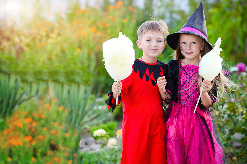 万圣节那天,小男孩和小女孩穿着女巫和刽子手的服装
