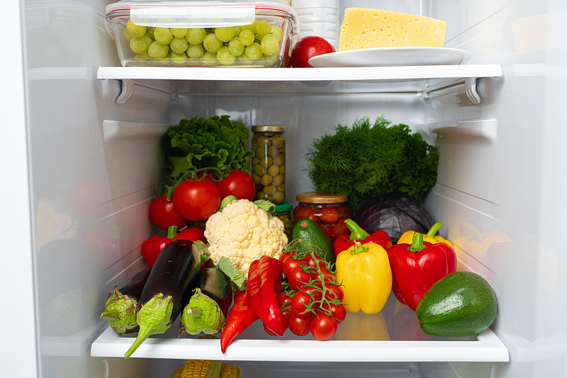 装满新鲜蔬菜的冰箱搁板靠近了