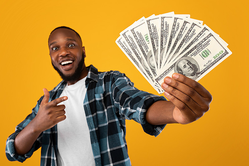 快乐的非洲裔美国人显示金钱在黄色背景