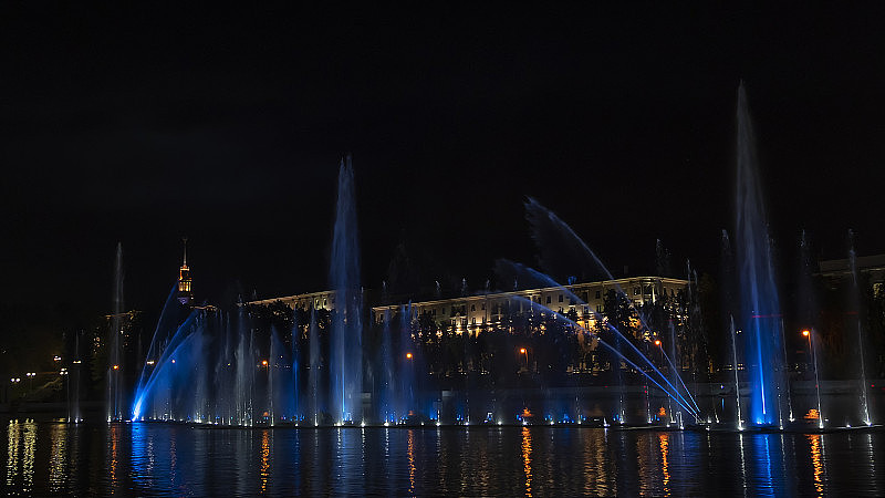 五彩缤纷的音乐喷泉在夜晚的河流上。喷泉在夜间照明。长时间的曝光。