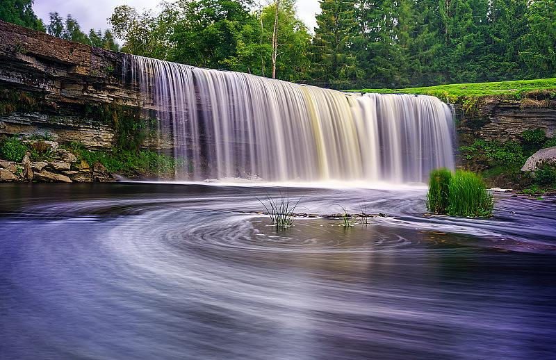 大河流瀑布在水中旋转在长曝光照片。