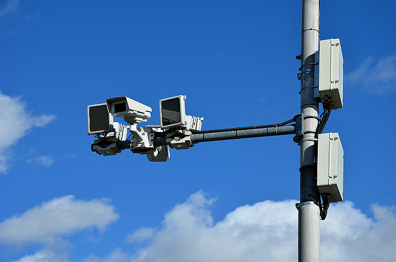 一个监控城市高速公路上交通车辆速度的摄像系统。任何超速驾驶的人都会收到罚款。两个方向的两个摄像头