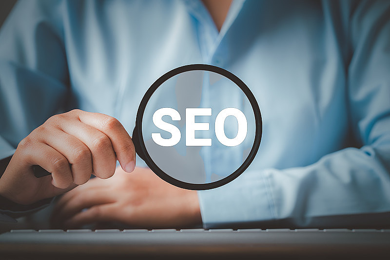 SEO搜索引擎优化，女人握着放大镜用文字SEO，提升网站排名流量的概念，优化你的网站在搜索引擎中的排名。
