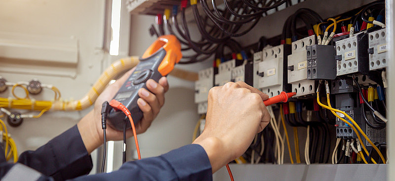 电气工程师使用测量设备检查断路器和电缆布线系统的电流电压，电气服务理念。