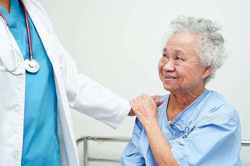 医生在护理医院帮助亚洲老年妇女残疾病人，医学理念。