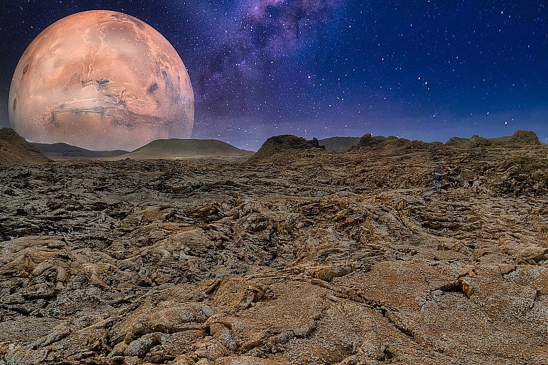 令人惊叹的镜头外星球岩石表面上的星空和一个大的行星背景
