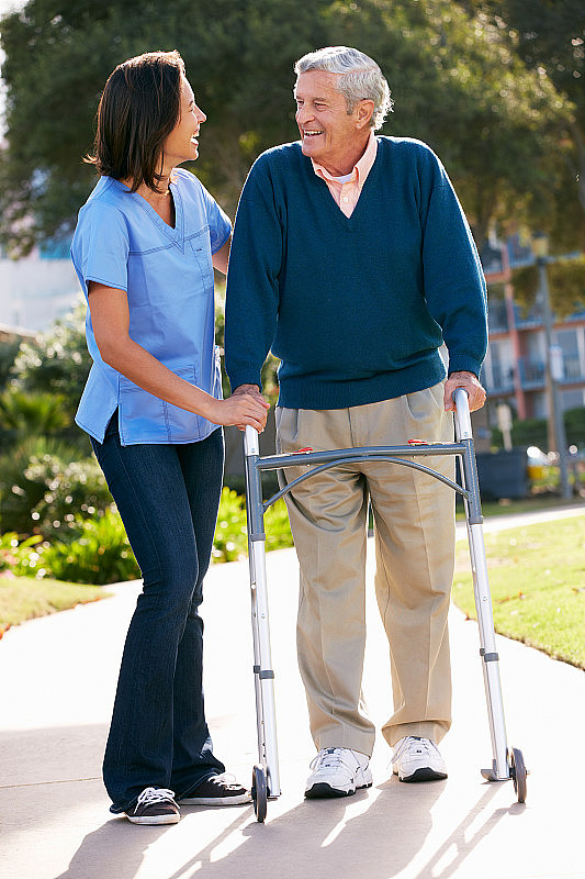 护理人员帮助老年人行走架