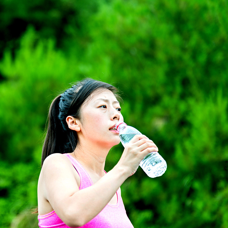 年轻的亚洲女人喝水