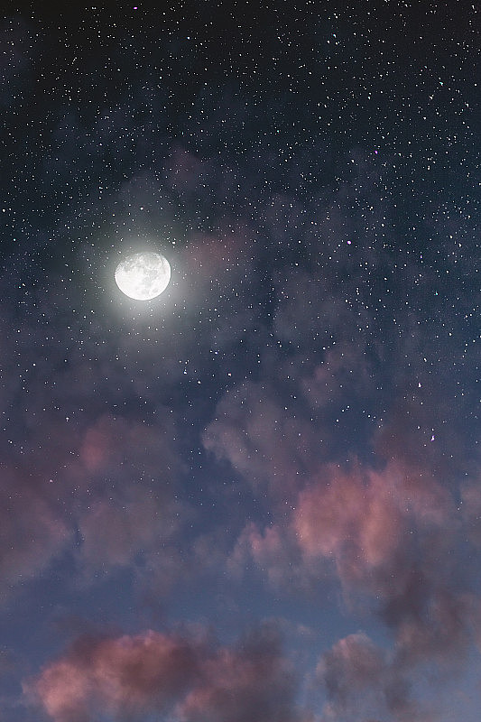 明亮的月亮穿过粉红色的云在夜空中