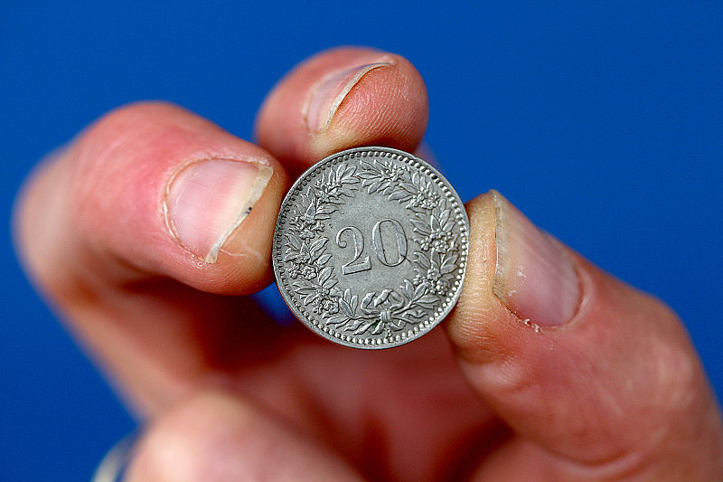 手指握着瑞士的旧硬币