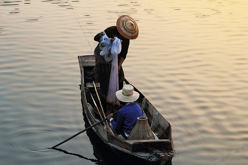 日出时分，亚洲渔民在美丽的自然风光的邦普拉湖上用渔网捕鱼。泰国春武里省的邦普拉水库