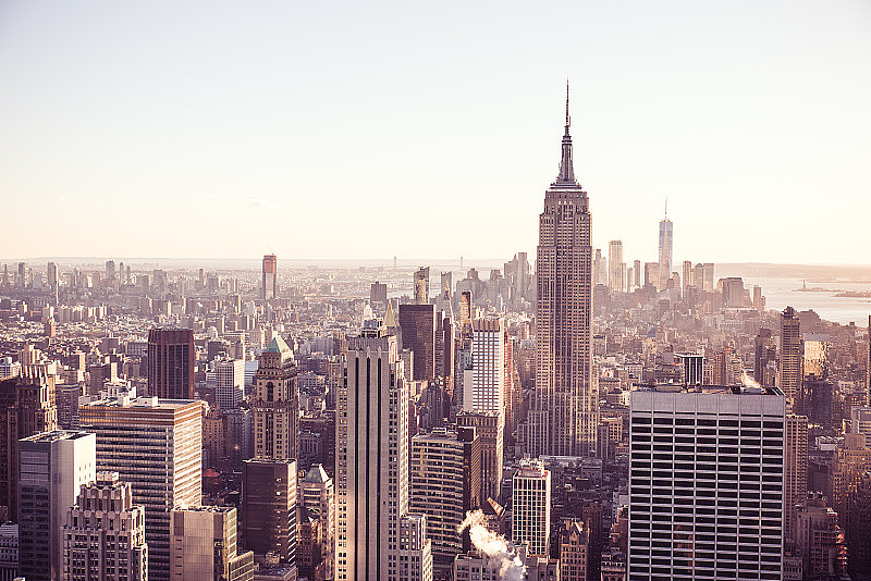 纽约市-美国。日落时分，欣赏曼哈顿下城著名的帝国大厦和摩天大楼的天际线。