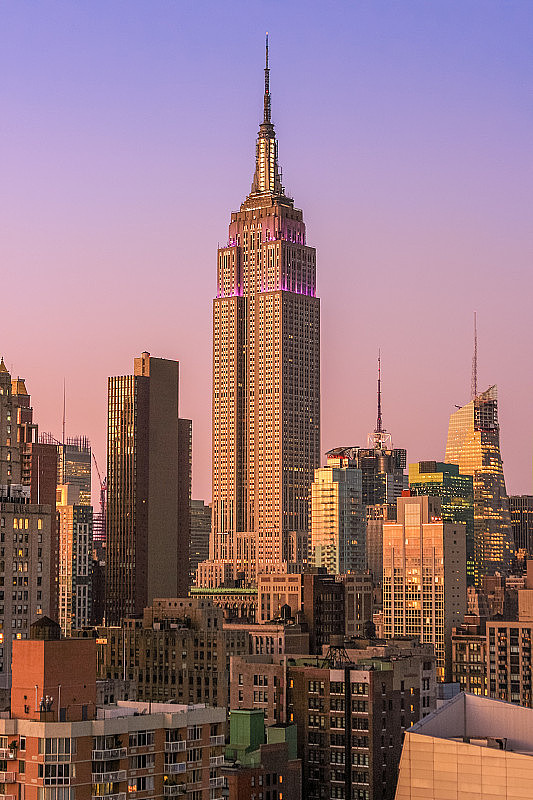 帝国大厦和纽约天际线与曼哈顿中城摩天大楼在日落与橙色晴朗的天空。